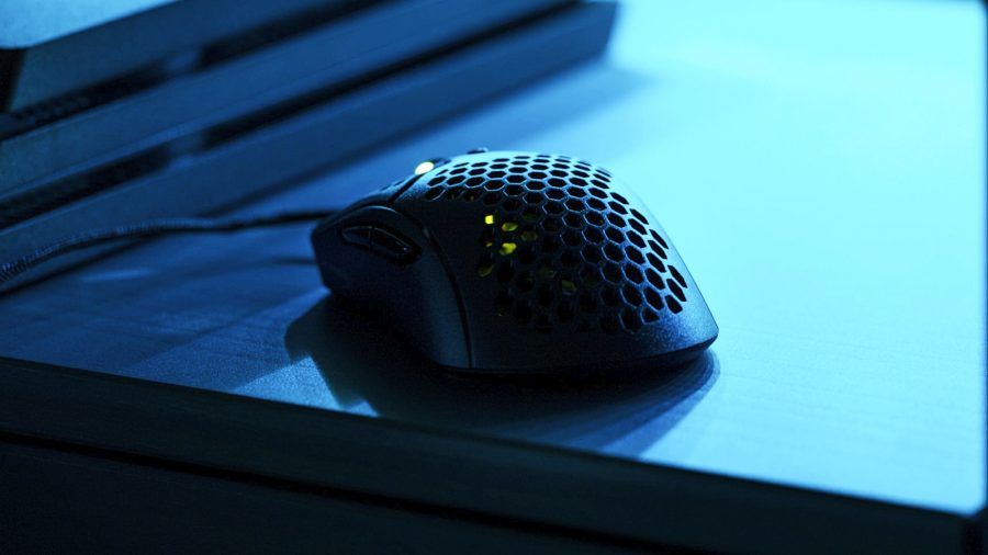 The HyperX Pulsefire Dart atop a desk, in a dimily lit room